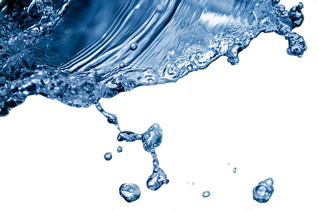 En esta foto aparece un charco de agua un azul oscuro salpicando gotas de más pequeñas a más grandes